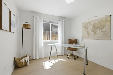 a view of a workspace with furniture and a window