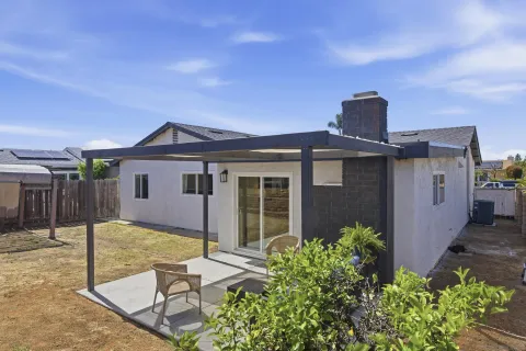 a view of a house with backyard and sitting area