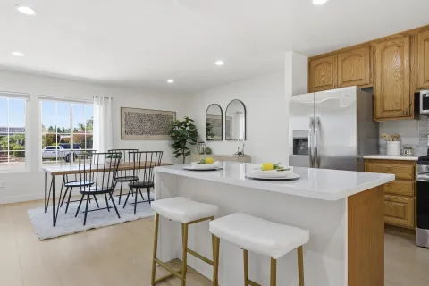 a kitchen with granite countertop a table chairs stove and refrigerator