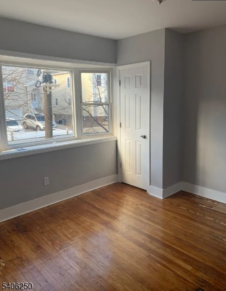 543 Court Street Elizabeth Port, NJ 07206 - Photo 2 of 7 a view of an empty room with wooden floor and a window