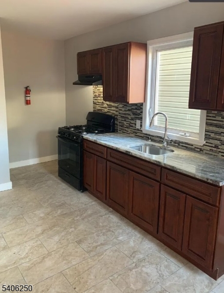 543 Court Street Elizabeth Port, NJ 07206 - Photo 4 of 7 a kitchen with stainless steel appliances granite countertop a sink stove and cabinets