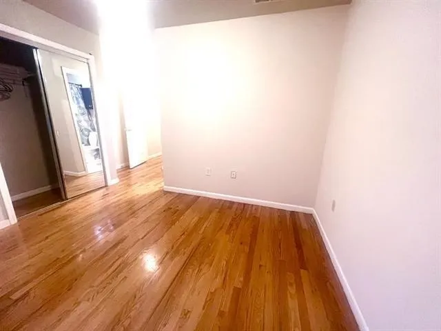 a view of a room with wooden floor and a window