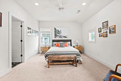 a bedroom with a bed a chair and painting on the wall