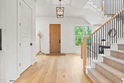 a view of a hallway with wooden floor and staircase