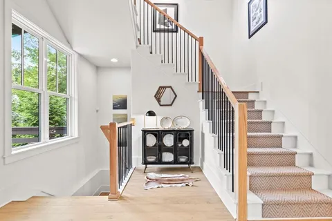 a view of staircase with wooden floor and windows