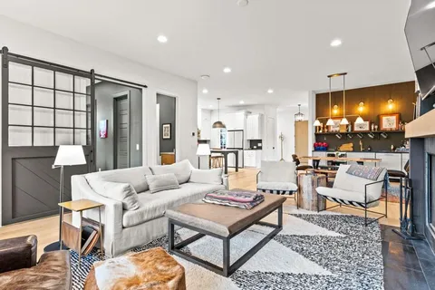 a kitchen with stainless steel appliances granite countertop a table chairs sink and cabinets