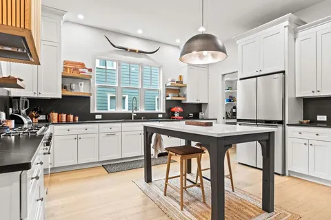 a kitchen with white cabinets and white appliances