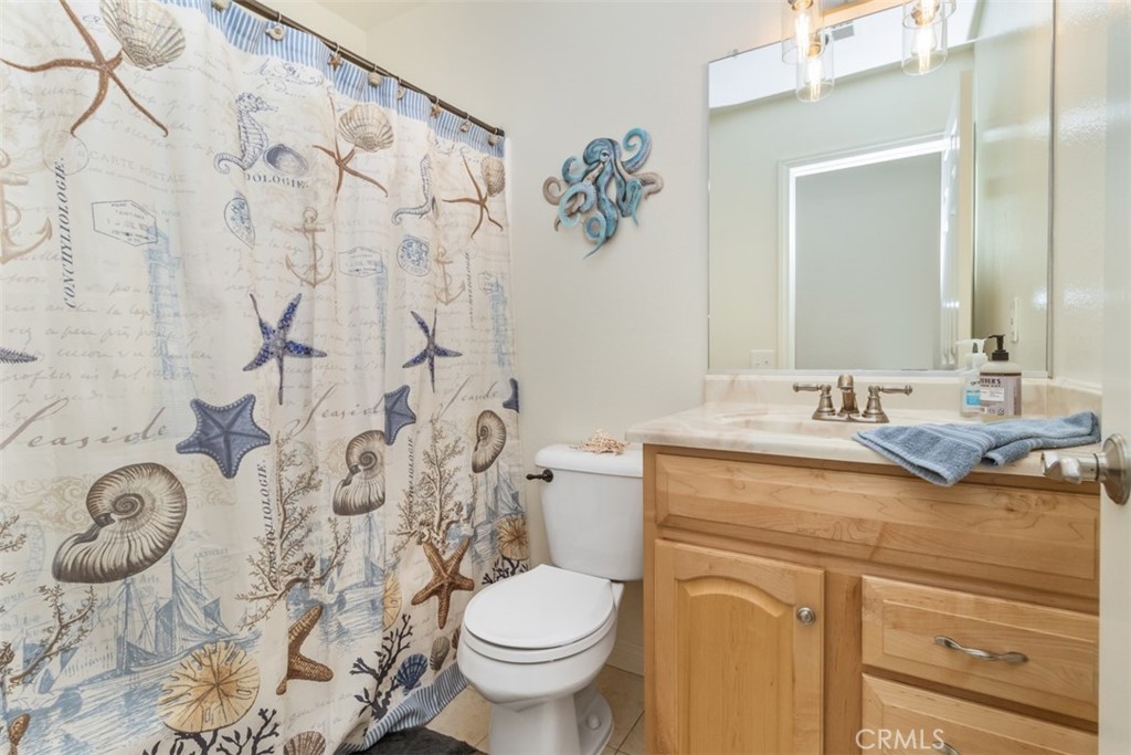 27432 Pinavete Mission Viejo, CA 92691 - Photo 27 of 37 a bathroom with a granite countertop sink a toilet and a mirror