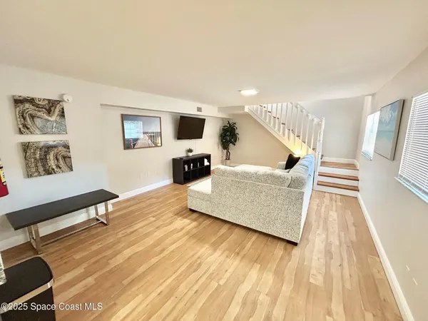 a living room with furniture and a wooden floor