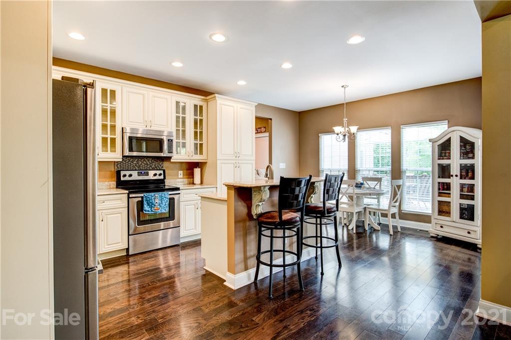 1637 State Rd S-46-1102, Unit 4 York, SC 29745 - Photo 13 of 39 a kitchen with stainless steel appliances granite countertop a stove top oven a sink a dining table and chairs with wooden floor