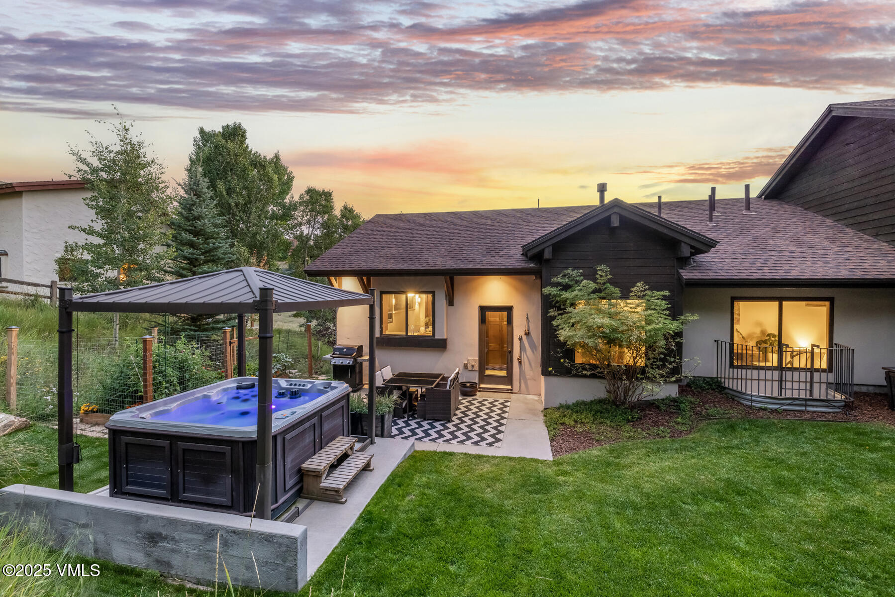 2310 Old Trail Road, Unit A Avon, CO 81620 - Photo 18 of 36 a view of a patio with table and chairs with wooden floor and fence