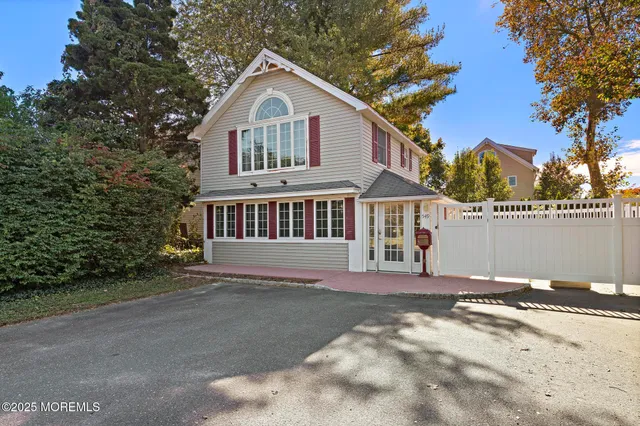a view of a house with a yard and large trees