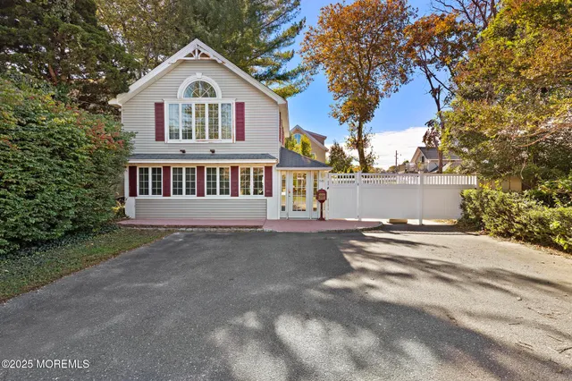 a view of a house with a yard and large trees