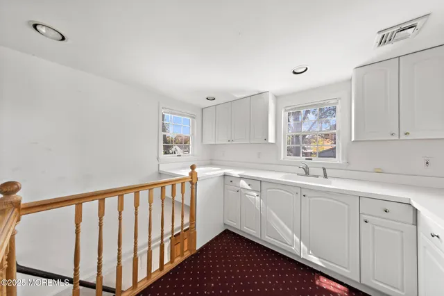 a kitchen with white cabinets a sink and dishwasher