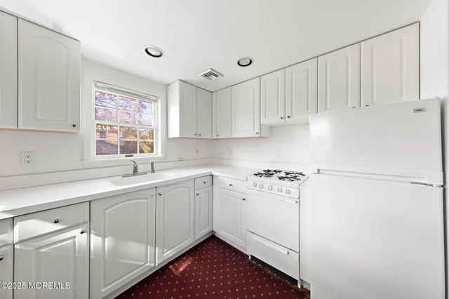 a kitchen with a sink cabinets and window