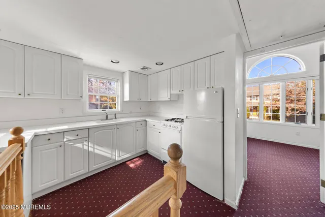 a kitchen with a refrigerator a stove a sink and a window