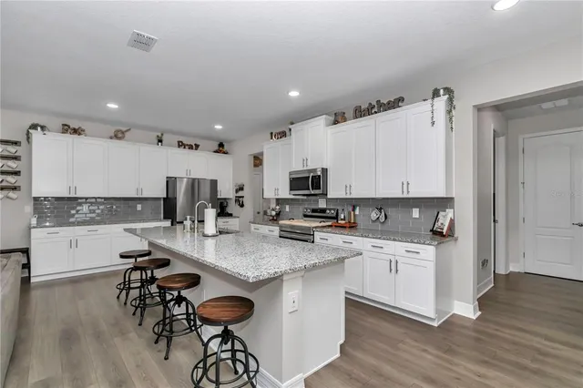 a kitchen with stainless steel appliances granite countertop a refrigerator and a stove top oven