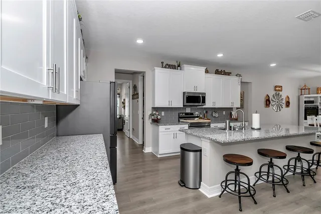 a kitchen with granite countertop a refrigerator and a sink