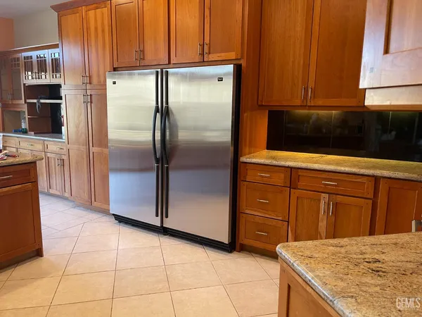 a kitchen with stainless steel appliances granite countertop a refrigerator and a stove top oven