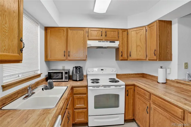 a kitchen with a sink stove top oven and cabinets