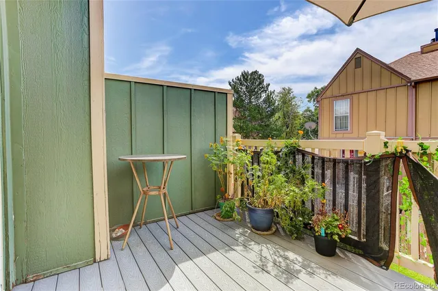a view of a balcony with wooden floor and chair