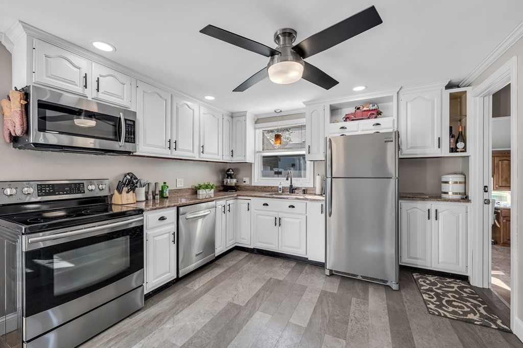39 Rita Street Springfield, MA 01118 - Photo 12 of 42 a kitchen with granite countertop a refrigerator stove and microwave