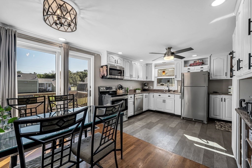 39 Rita Street Springfield, MA 01118 - Photo 10 of 42 a kitchen with stainless steel appliances granite countertop a stove a refrigerator a kitchen island a table and chairs