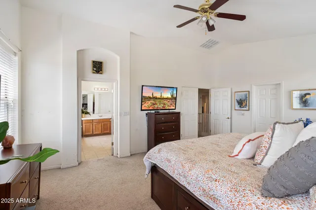 a view of a livingroom with wooden floor and a ceiling fan