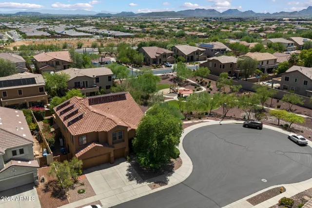 an aerial view of multiple houses with a yard