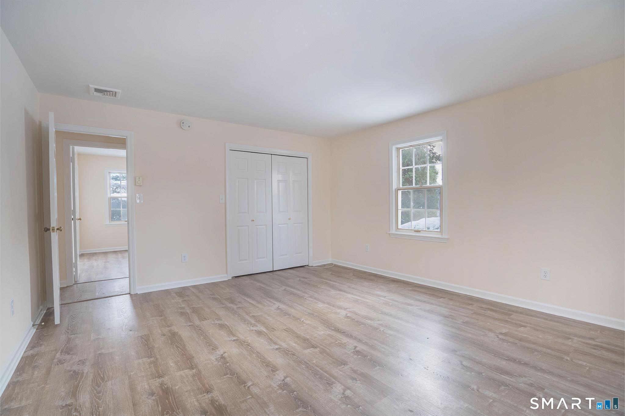 4 Currycross Road, Unit 4 Madison, CT 06443 - Photo 15 of 30 a view of an empty room with wooden floor and a window