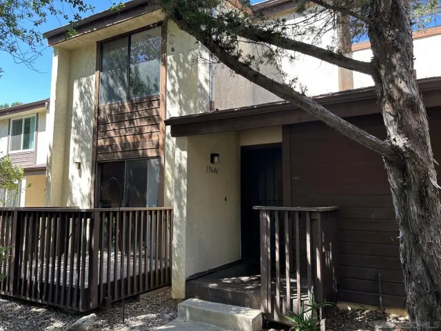 a view of a house with a small yard and wooden fence