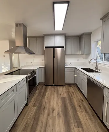 a kitchen with granite countertop a sink stainless steel appliances and cabinets