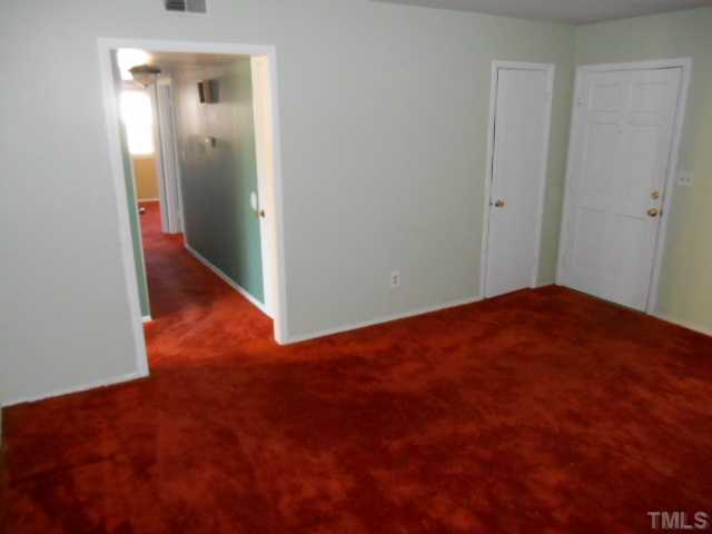 907 Wyldewood Road Durham, NC 27704 - Photo 4 of 9 an empty room with wooden floor and closet