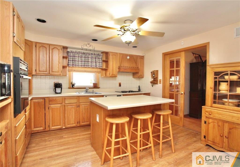386 East Pleasant Grove Road Jackson, NJ 08527 - Photo 14 of 24 a kitchen with a stove a sink dishwasher and a refrigerator with wooden floor