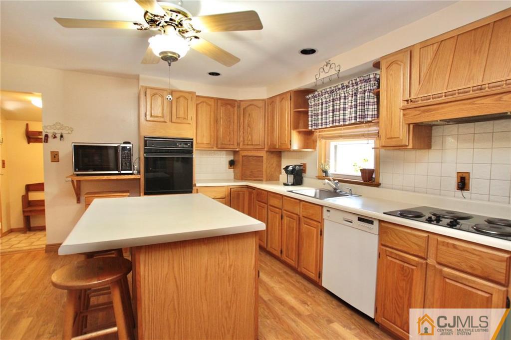 386 East Pleasant Grove Road Jackson, NJ 08527 - Photo 16 of 24 a kitchen with kitchen island granite countertop a sink appliances cabinets and counter space