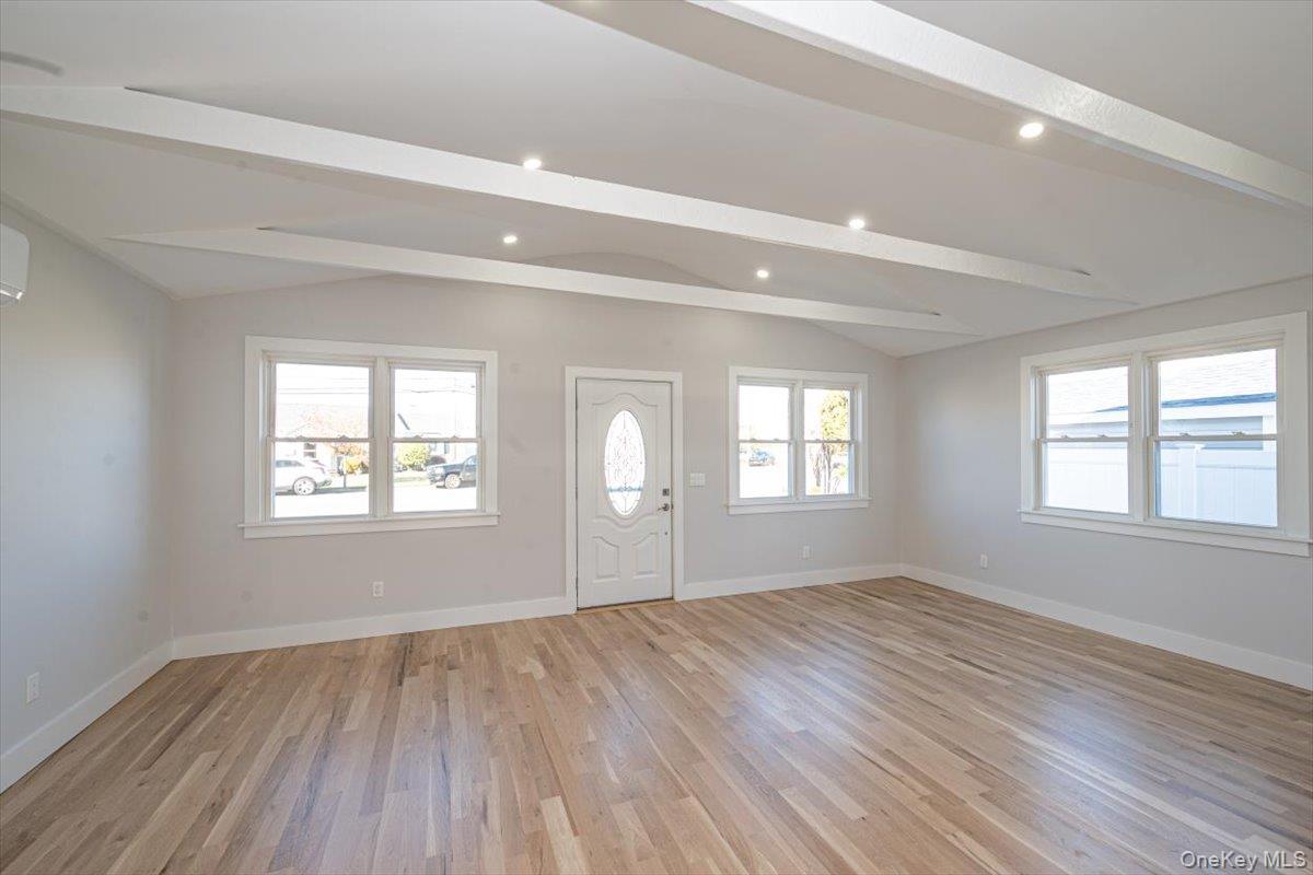 55 Alhambra Road Massapequa, NY 11758 - Photo 16 of 38 a view of empty room with wooden floor and fan
