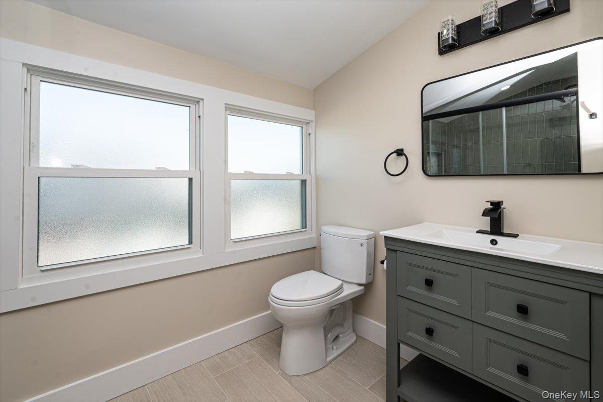 55 Alhambra Road Massapequa, NY 11758 - Photo 26 of 38 a bathroom with a toilet sink and mirror