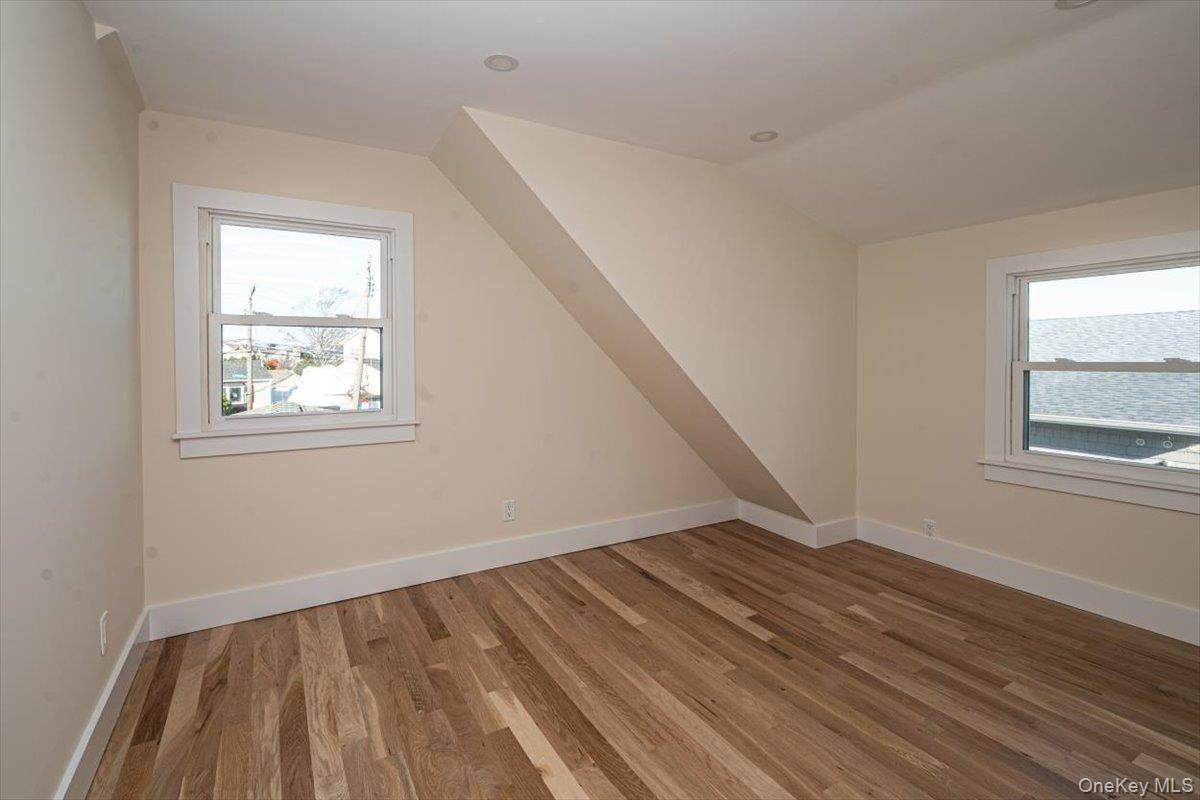 55 Alhambra Road Massapequa, NY 11758 - Photo 29 of 38 a view of an empty room with wooden floor and a window