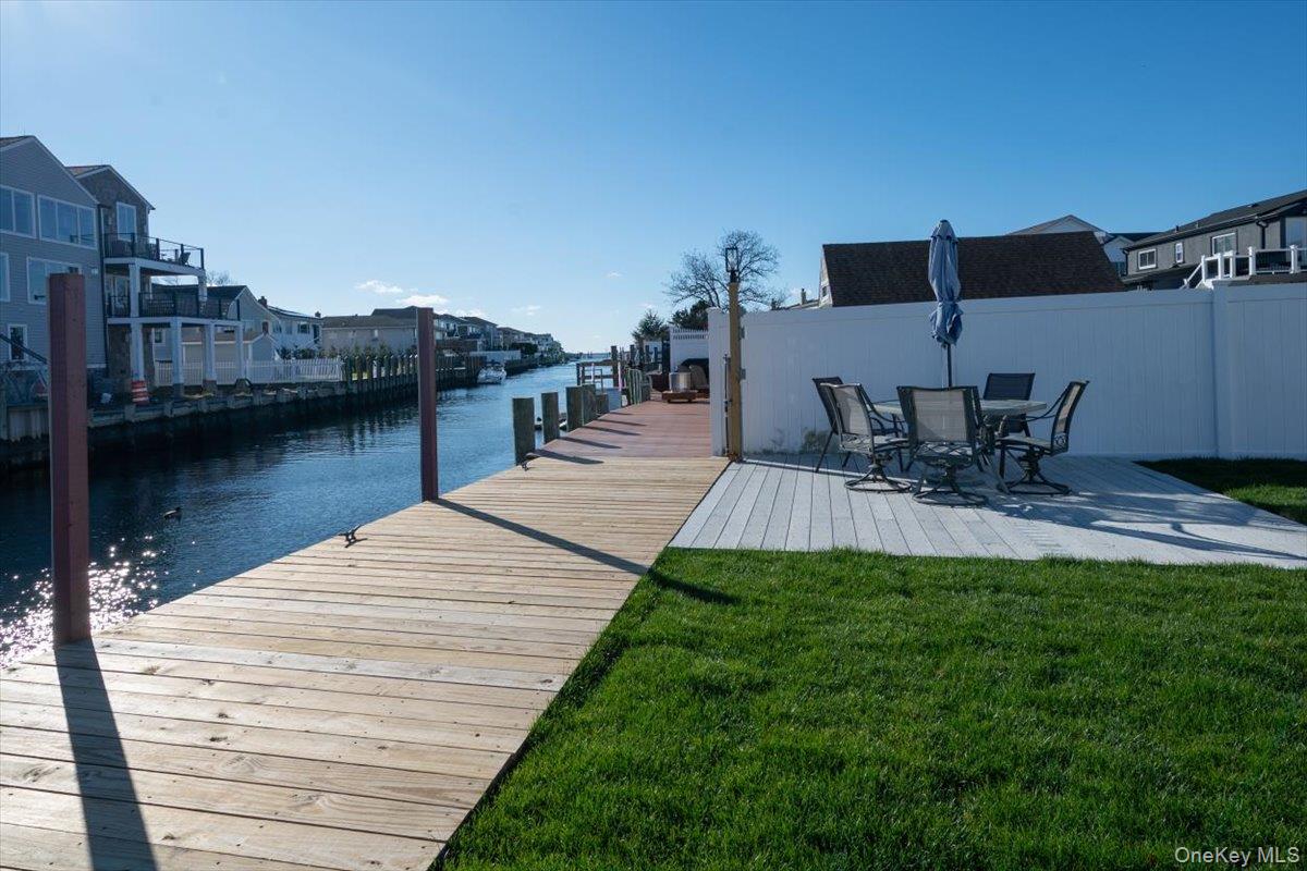 55 Alhambra Road Massapequa, NY 11758 - Photo 3 of 38 a view of a lake with table and chairs