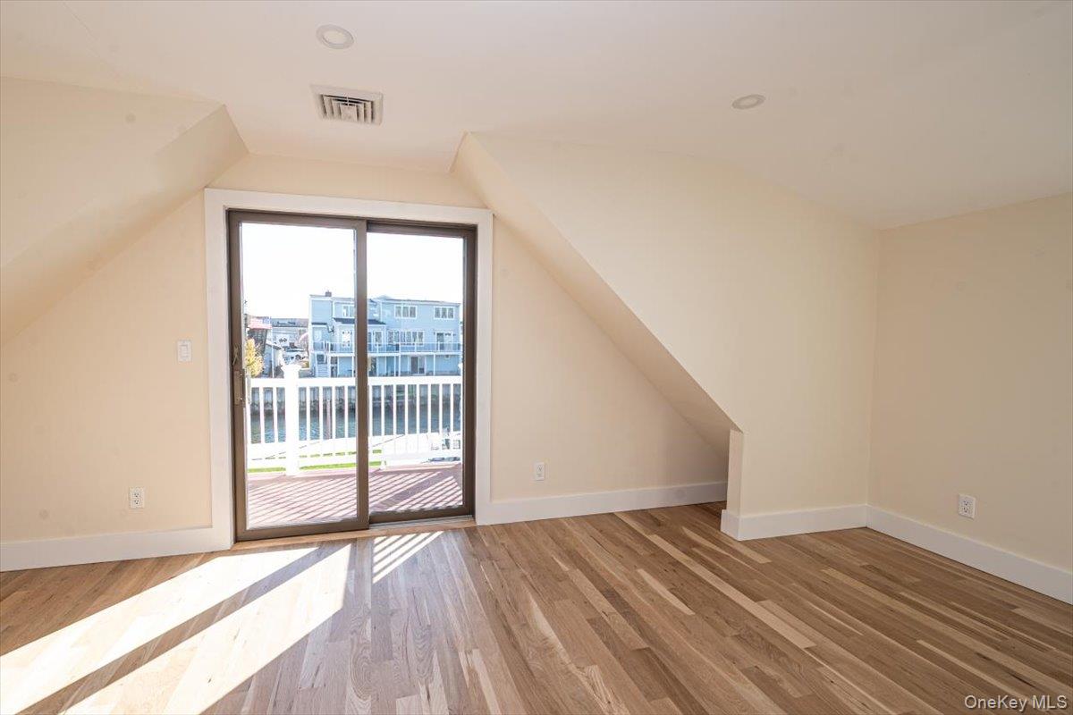 55 Alhambra Road Massapequa, NY 11758 - Photo 31 of 38 a view of an empty room with wooden floor and a window