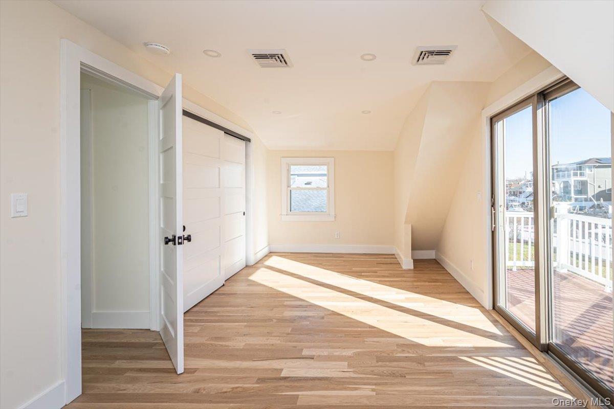 55 Alhambra Road Massapequa, NY 11758 - Photo 33 of 38 a view of an empty room with wooden floor and a window