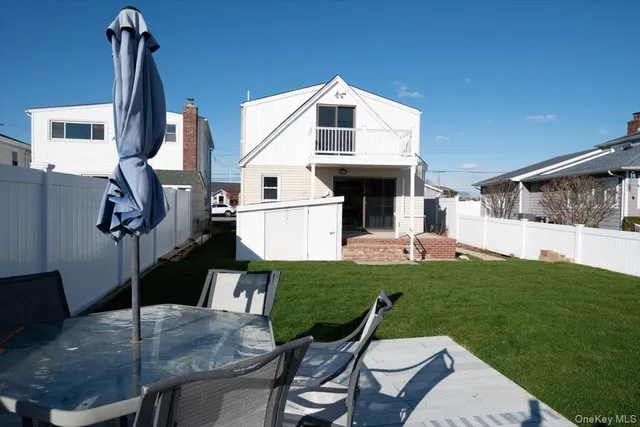 a large kitchen with stainless steel appliances granite countertop a refrigerator a sink dishwasher a stove and white countertops with wooden floor