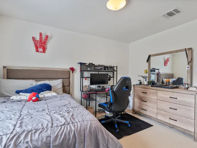 a bedroom with a bed a desk and chair