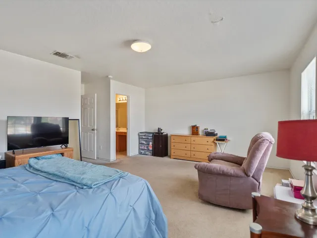 a bedroom with furniture and a flat screen tv