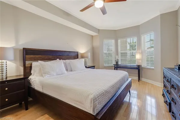 a bedroom with a bed and a flat tv screen on dresser