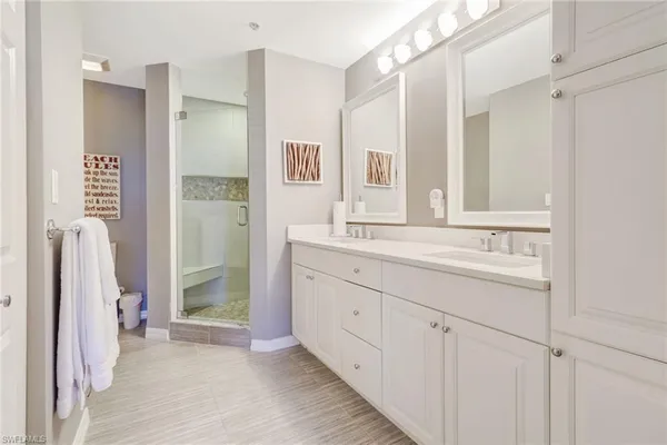 a bathroom with a double vanity sink a mirror and a shower