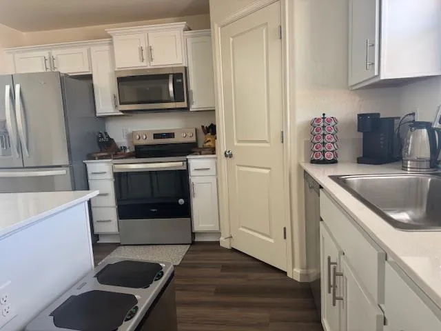 a kitchen with stainless steel appliances a stove a sink and a microwave