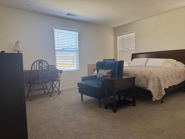 a bedroom with a bed chair and window