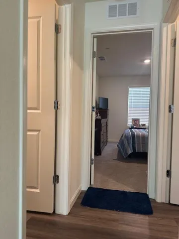 a view of a bedroom with a bed and wooden floor