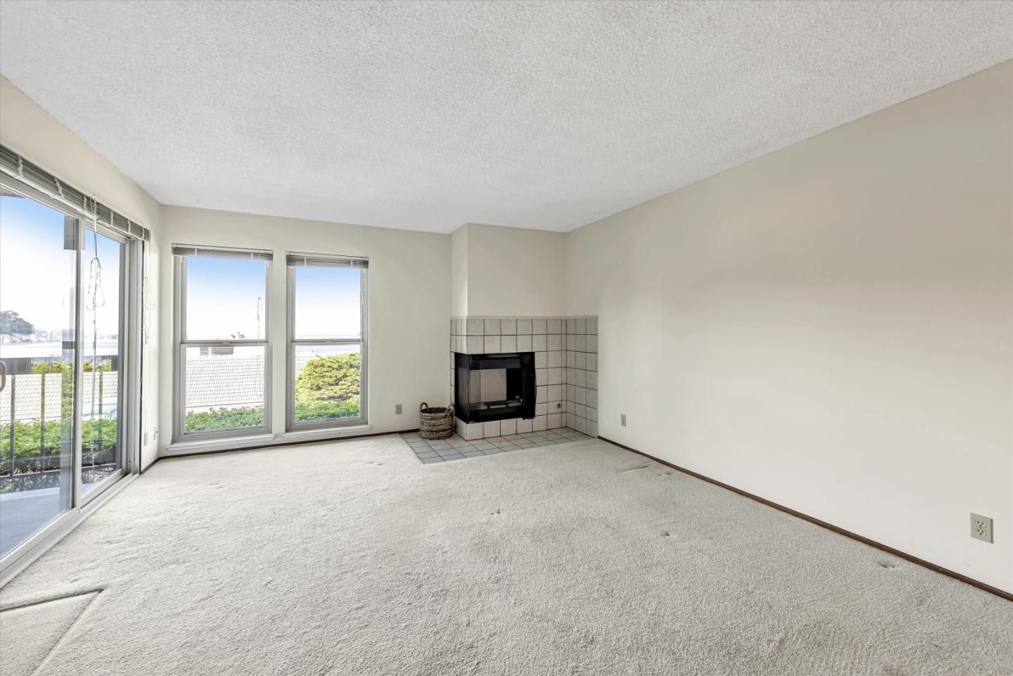 459 Roberts Road Pacifica, CA 94044 - Photo 26 of 50 an empty room with a fireplace and large windows